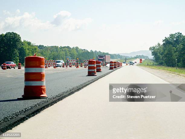 view of open road and construction markers - road works stockfoto's en -beelden