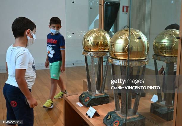 Boys view reproductions of the Intercontinental Cup trophies won by AC Milan in 1989 and 1990, at the exhibition "Oltre il Sogno, L'emozione del...