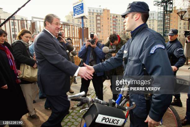 Minister of the Interior Daniel Vaillant shakes hands with a police officer on a bicycle patrol in the 10th arrondissement of the capital, on...