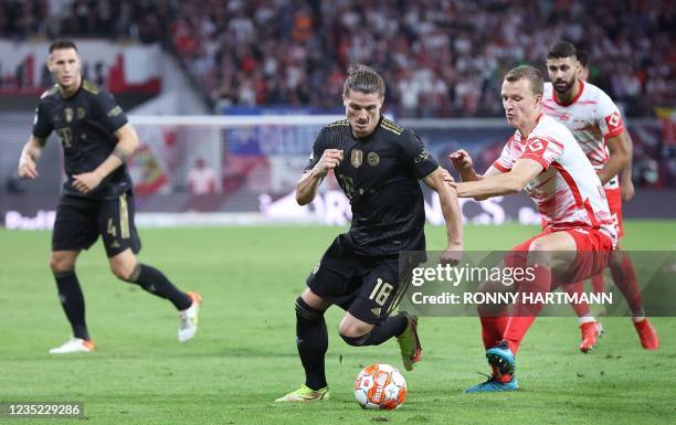 Bayern Munich's Austrian midfielder Marcel Sabitzer and Leipzig's German defender Lukas Klostermann compete for the ball during the German first...