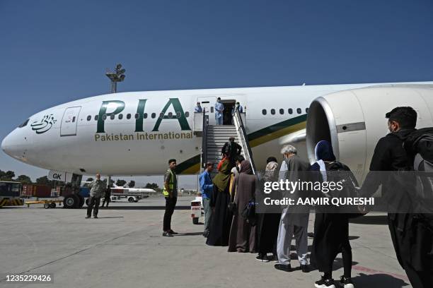 Passengers board a Pakistan International Airlines flight, the first commercial international flight since the Taliban retook power last month, at...