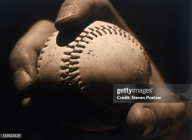 close-up of a hand holding a baseball - baseball pitcher close up stock pictures, royalty-free photos & images