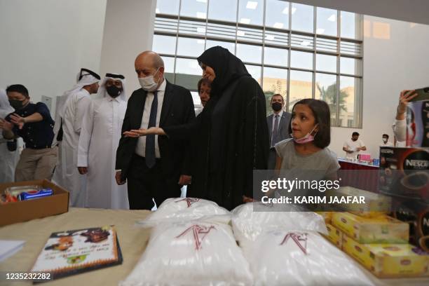 French Foreign Minister Jean-Yves Le Drian , accompanied by Qatars assistant Foreign Minister Lolwah al-Khater , visits refugees from Afghanistan at...