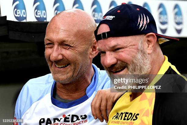 French former football player Fabien Barthez speaks and smiles with French former rugby player and chef Philippe Etchebest prior to a friendly...