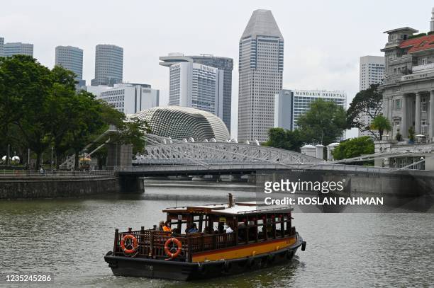 People ride on a boat tour along the Singapore River in Singapore on September 14, 2021.