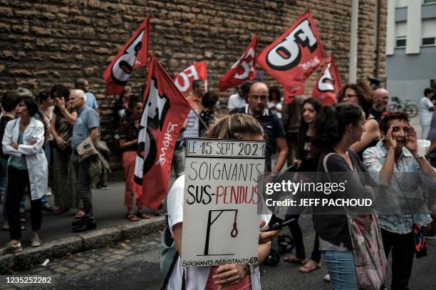 Nursing staff member holds a sign as she demonstrates in front of The A.R.S in Lyon, south-eastern France on September 14 against mandatory health...