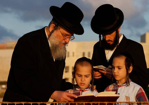 Ultra-Orthodox Jewish men and children perform the "Tashlich" ritual in the coastal city of Netanya on September 14, 2021 during which "sins are cast...