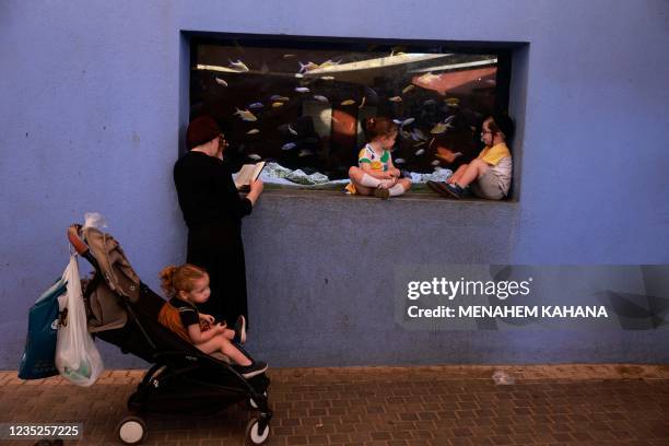 An ultra-Orthodox Jewish family pray in front of a fish aquarium at a zoo in the ultra-Orthodox Israeli city of Bnei Brak near Tel Aviv on September...