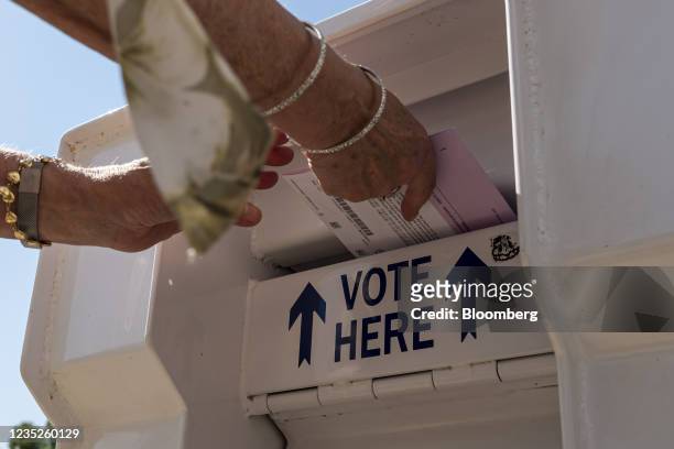 Voter drops a ballot into a ballot box during the gubernatorial recall election in Martinez, California, U.S., on Tuesday, Sept. 14, 2021....