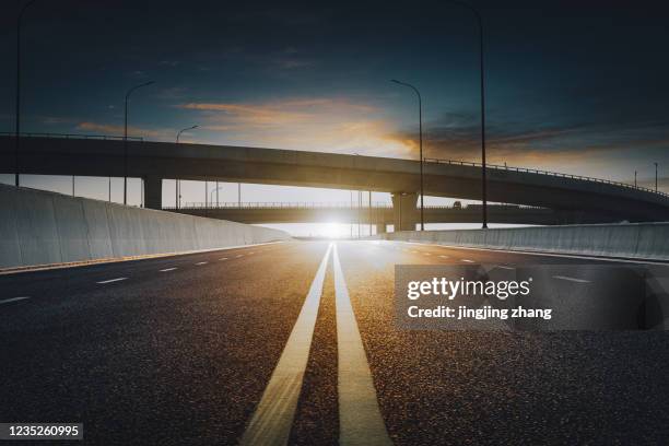 an overpass on the highway to the city - straßenmarkierung stock-fotos und bilder