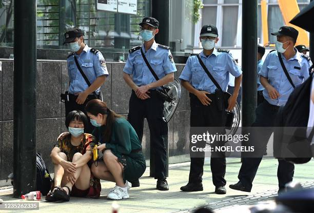 People gather at the Evergrande headquarters building in Shenzhen, southeastern China on September 15 as the Chinese property giant said it is facing...