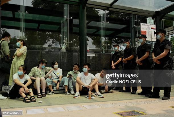 People gather at the Evergrande headquarters building in Shenzhen, southeastern China on September 15 as the Chinese property giant said it is facing...