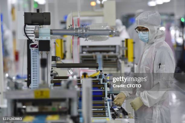 Worker produces FPC adhesive at a dust-free workshop of an enterprise in Yancheng, East China's Jiangsu province, Sept. 15 to supply apple, Lenovo,...