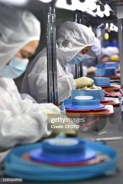 Workers produce FPC adhesive at a dust-free workshop of an enterprise in Yancheng, East China's Jiangsu province, Sept. 15 to supply apple, Lenovo,...