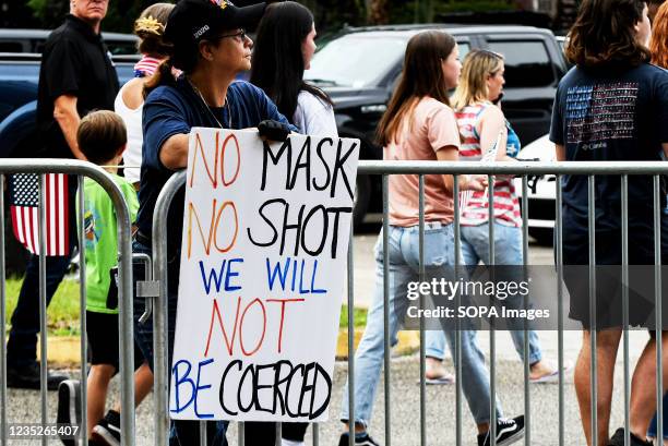 Woman holds a placard outside a meeting of the Volusia County School Board in Deland. The school board voted 3-2 to modify the mandatory school mask...