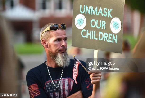 Daniel Layton holds a placard outside a meeting of the Volusia County School Board in Deland. The school board voted 3-2 to modify the mandatory...