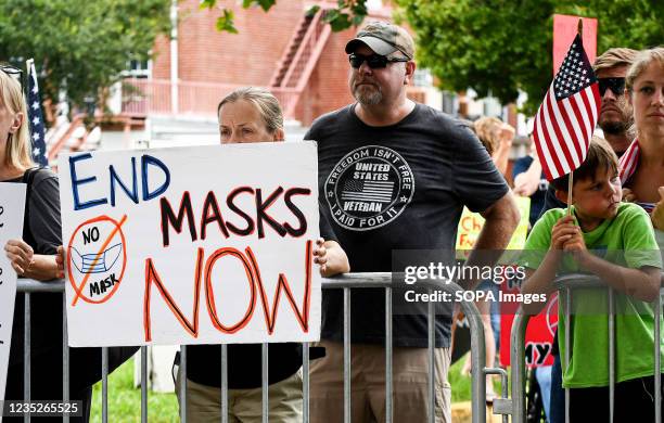 Woman holds a placard outside a meeting of the Volusia County School Board in Deland. The school board voted 3-2 to modify the mandatory school mask...