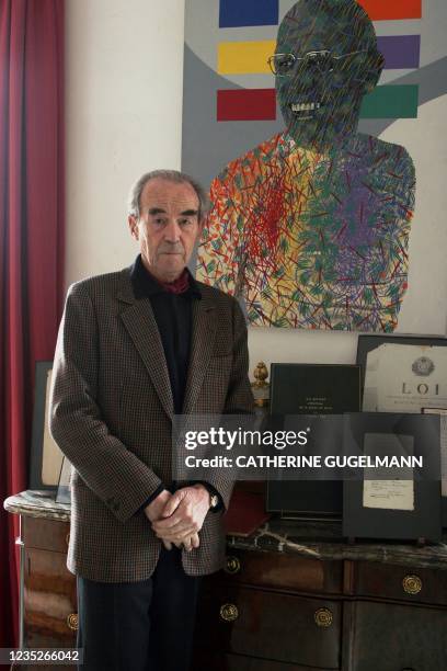 Le sénateur Robert Badinter pose devant un tableau représentant le philosophe Michel Foucault, à côté notamment du texte de loi instaurant...