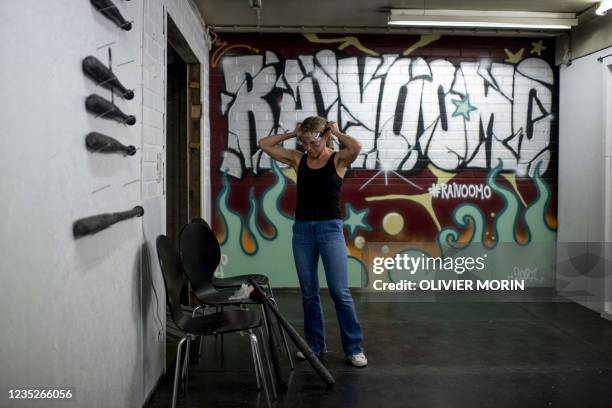 Finland's Sanna Sulin puts on safety glasses before destroying printers and other devices in the rage room "Raivomoo" on September 14, 2021 in...