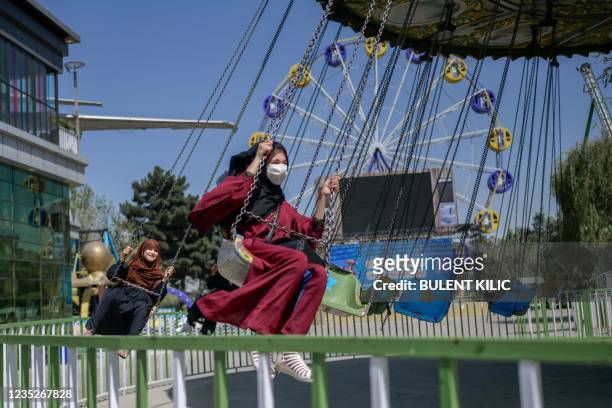 Youths enjoy a ride at an amusement park in Kabul on September 15, 2021.