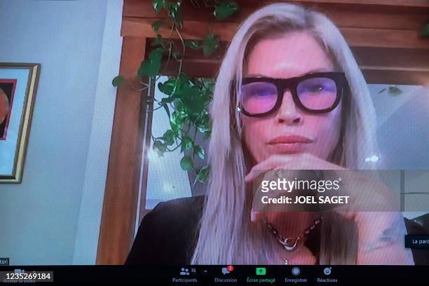 This photograph shows US former model Carre Otis on a screen during a video-conference on violence against women in the fashion industry, at the...