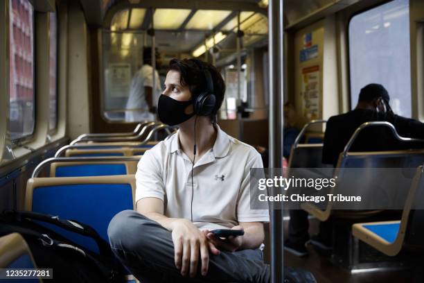 David Cedras, de 25 aÃ±os, con tapabocas mientras viaja en un tren de la Autoridad de Transporte de Chicago, en el centro de la ciudad el 9 de junio...