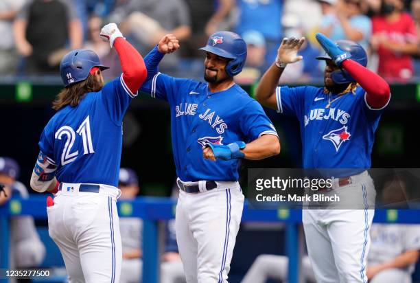 Bo Bichette of the Toronto Blue Jays celebrates his three-run home run with teammates Marcus Semien and Vladimir Guerrero Jr. #27 in the first inning...