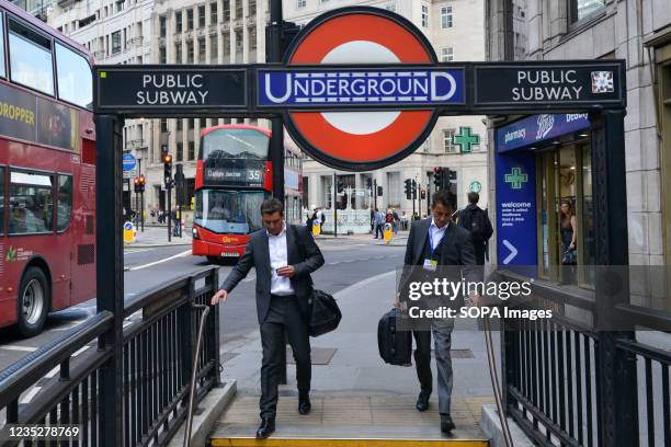 Commuters are seen entering Monument underground station, in London.
