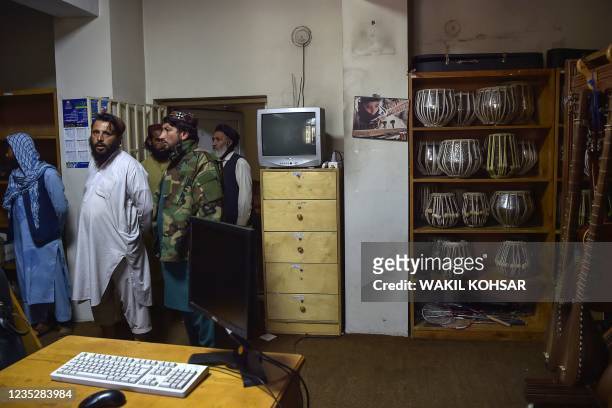 This photo taken on September 14, 2021 shows Taliban fighters standing in a room where instruments are kept at the Afghanistan National Institute of...
