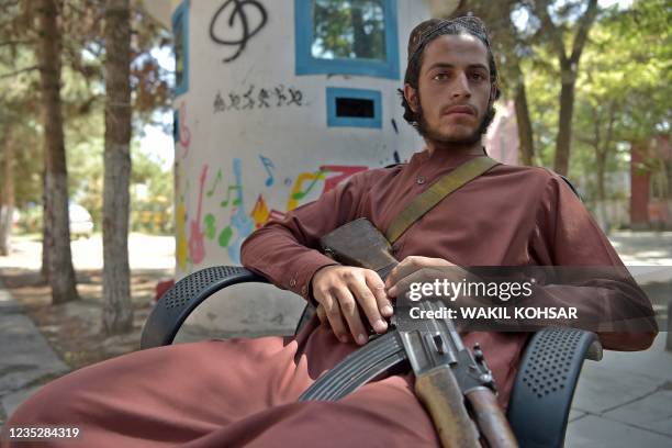 This photo taken on September 14, 2021 shows a Taliban fighter sitting in a courtyard at the Afghanistan National Institute of Music in Kabul. - The...