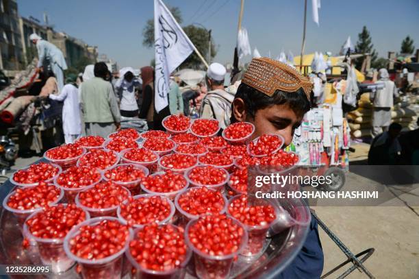 Boy selling pomegranate looks for customers at a temporary second-hand market in Kabul's Chaman-e-Huzuri neighbourhood on September 16, 2021.