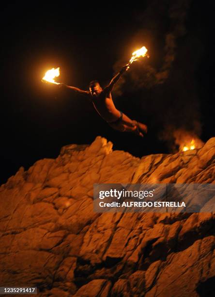 Cliff diver jumps with torches from 'La Quebrada' cliff in Acapulco, Mexico, on March 1, 2010. The tradition of 'La Quebrada' goes back to 1934, when...
