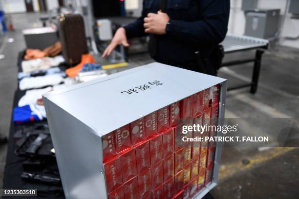 Seized cigarettes from China hidden in a air filtration container are displayed during an opening ceremony for a US Customs and Border Protection air...