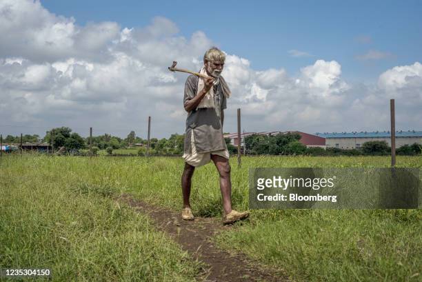 Farmer carries a hoe while walking to a corn field in Guna, Madhya Pradesh, India on Sunday, Sept. 12, 2021. Technology giants lining up to harness...