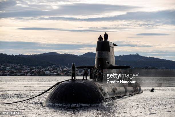 In this handout image provided by the Australian Defence Force, Royal Australian Navy submarine HMAS Sheean arrives for a logistics port visit on...
