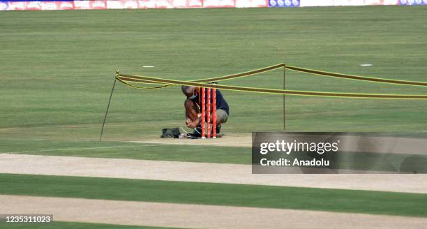 Pakistan Cricket Board official removes a camera installed behind the wickets at the Pindi Cricket Stadium following the cancellation of cricket...