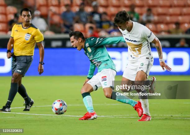 Club Leon midfielder Ivan Rodríguez goes down after crossing legs with Pumas forward Juan Dinenno during the Leagues Cup semifinal soccer match...