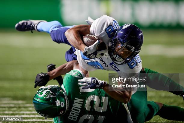 Chandler Worthy of the Toronto Argonauts is tackled at the end of a run by Blace Brown of the Saskatchewan Roughriders in the game between the...