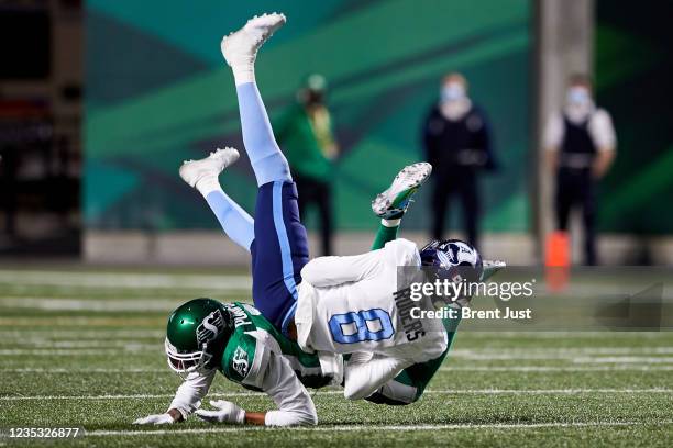Eric Rogers of the Toronto Argonauts is upended by Loucheiz Purifoy of the Saskatchewan Roughriders after making a catch in the game between the...