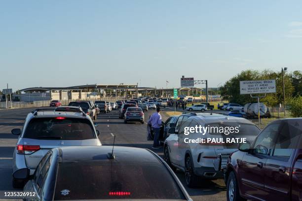People wait at the US-Mexico border at the Del Rio International Bridge, which is closed temporarily after an influx of migrants, in Del Rio, Texas...
