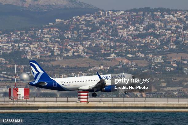 An Aegean Airlines Airbus A320 aircraft painted with the new livery and company logo as seen landing over the sea at runway 10/28 that is extended by...