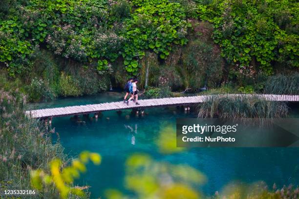 View on a wooden boardwalk traill leading tourists through Plitvice Lakes National Park in Croatia on September 15, 2021. In 1979, Plitvice Lakes...