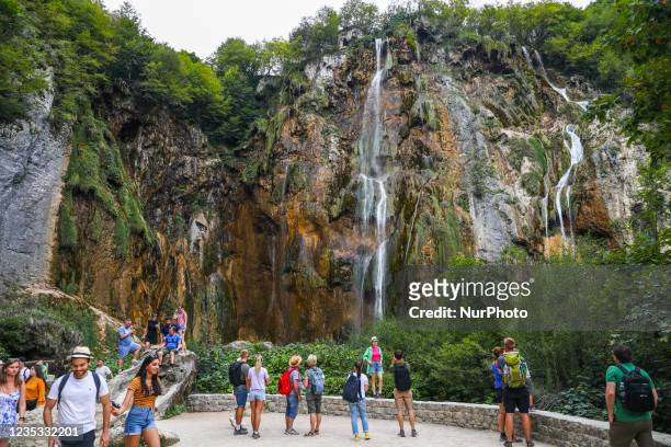 Tourists watch the Great Waterfall at Plitvice Lakes National Park in Croatia on September 15, 2021. In 1979, Plitvice Lakes National Park was...