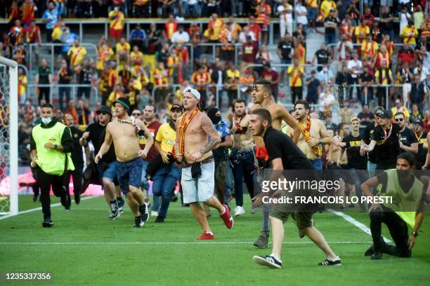 Lens' supporters invade the pitch during the French L1 football match between RC Lens and Lille at Stade Bollaert-Delelis in Lens, northern France,...