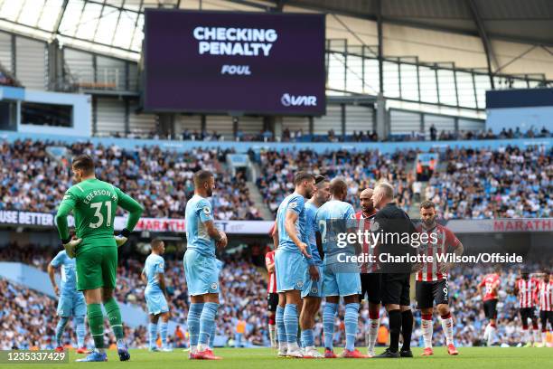 Referee Jonathan Moss speaks with Man City and Southampton players as VAR checks a possible penalty foul by Kyle Walker during the Premier League...