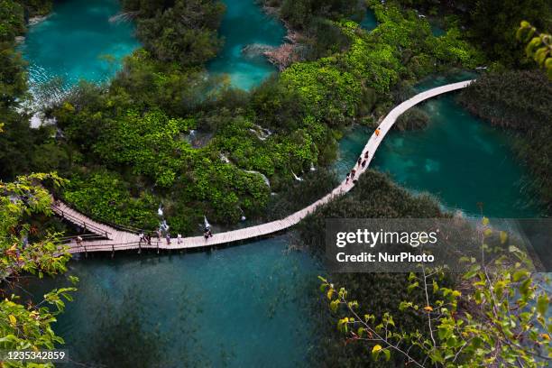 Tourists walk along a wooden path in Plitvice Lakes, Croatia on September 15, 2021.