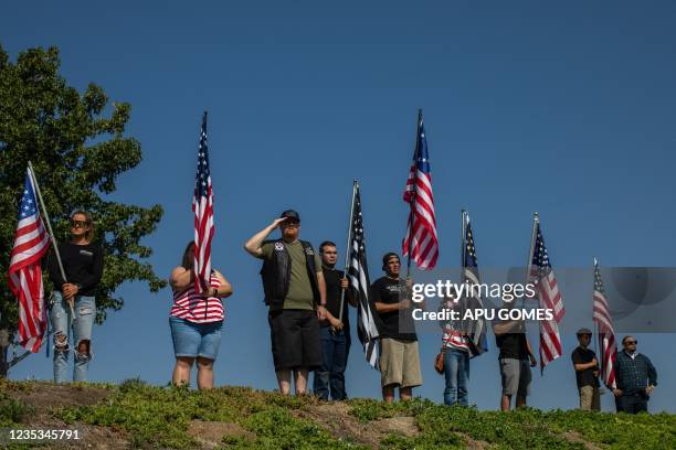 People line the street to watch the hearse carrying the casket of Marine Lance Cpt. Kareem Grant Nikoui as it arrives at the Harvest Christian...