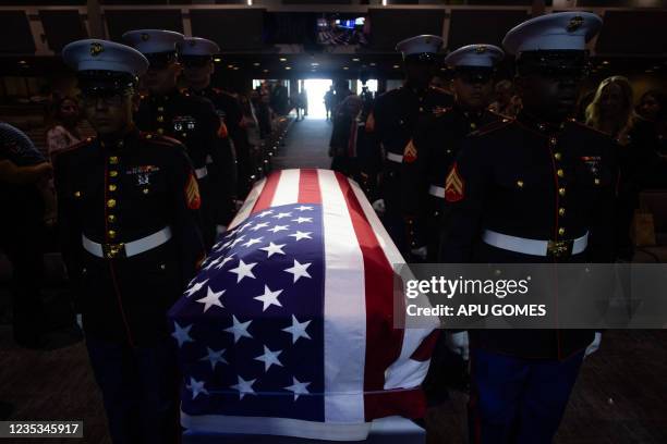 Military honor guard carries the flag-draped casket of Marine Lance Cpt. Kareem Grant Nikoui during a funeral ceremony inside the Harvest Christian...