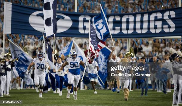 Connor Pay, Jacob Palu and Cosmo the mascot of the BYU Cougars lead the team onto the field before their game against the Arizona State Sun Devils...