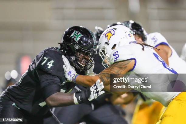 Gene Pryor of the Hawaii Rainbow Warriors and Alii Matau of the San Jose State Spartans battle at the line of scrimmage during the second half of an...